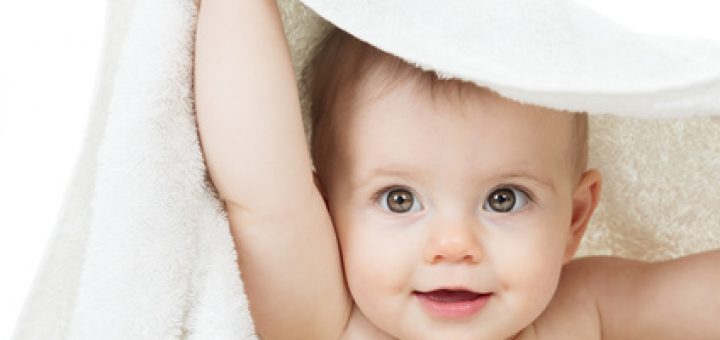 Zdjęcie przedstawiające niemowlę okryte ręcznikiem